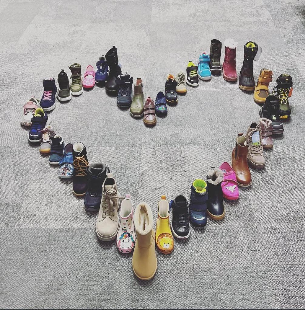 Kinderschuhe in Herzform arrangiert – Liebe zum Kinderschuh